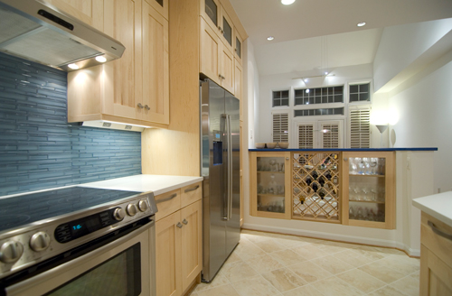 After kitchen photo with light tan cabinetry, blue tile and stainless appliances - view 1