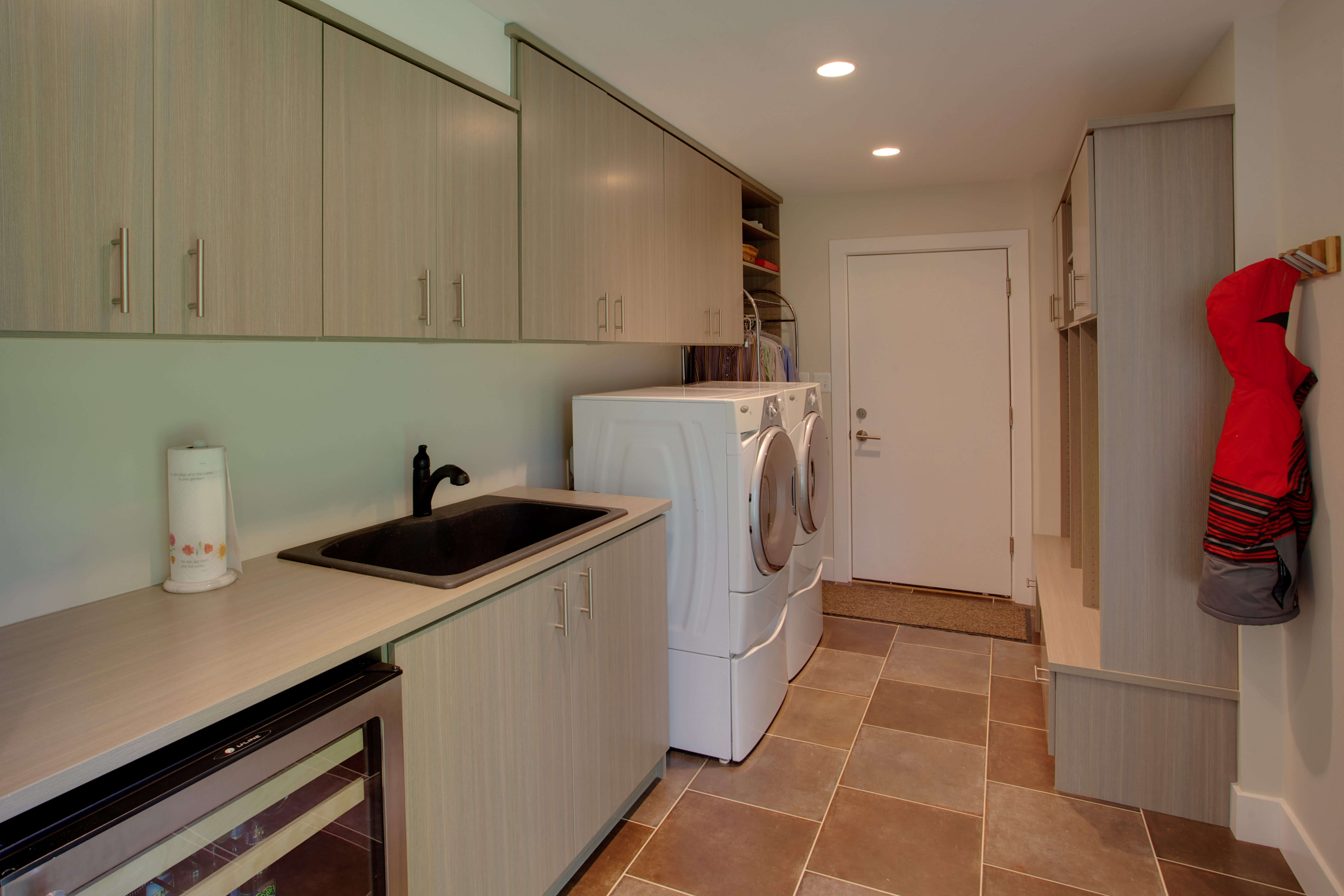 Laundry with light brown cabinetry