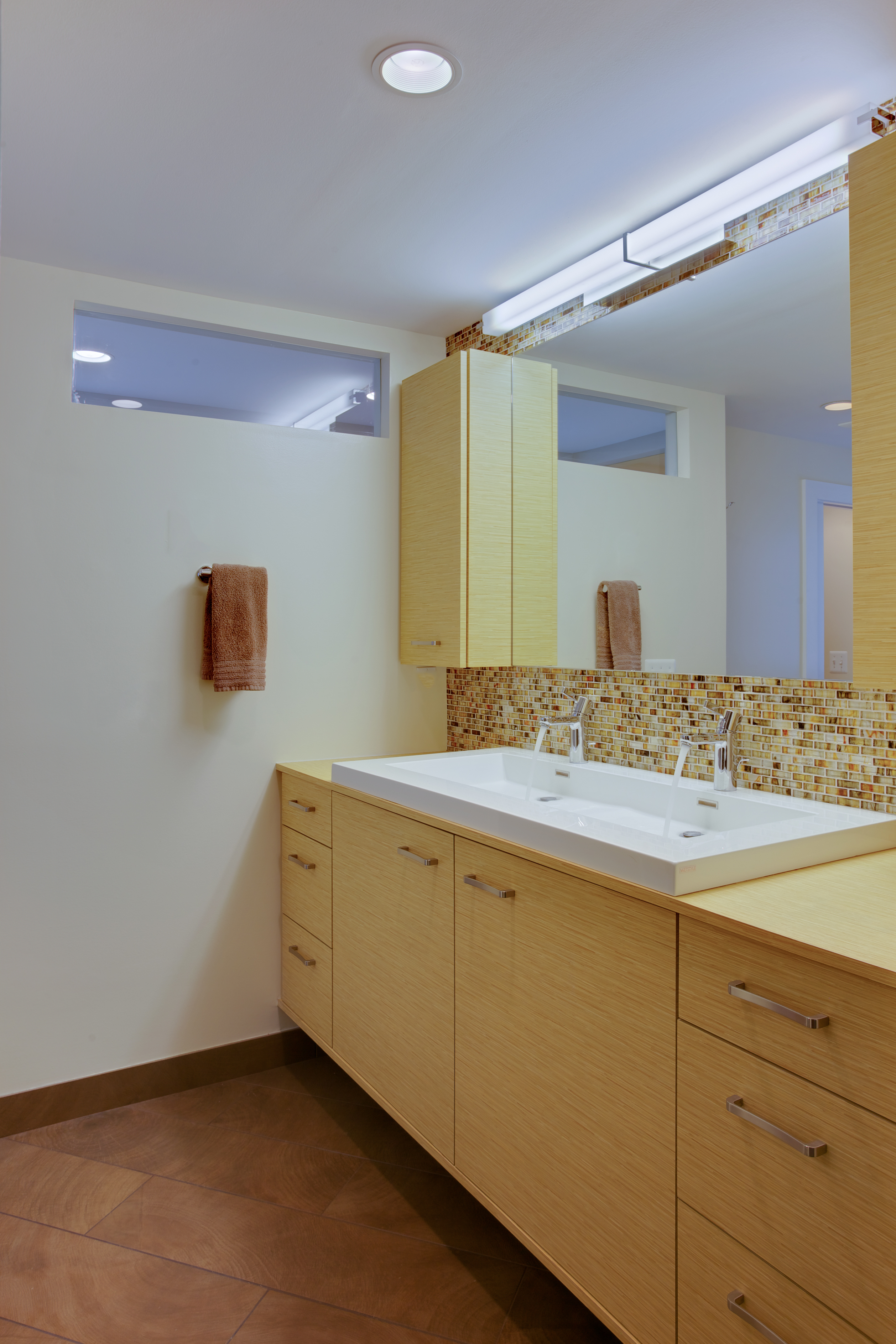 Bathroom with double vanity and yellow, wood cabinetry - view 2
